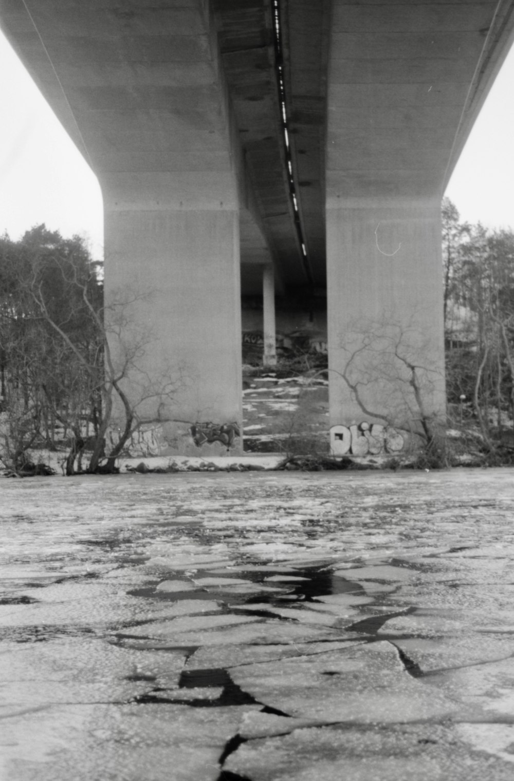 a black and white photo of a bridge over water