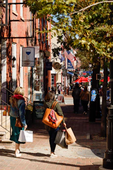A lively street scene in New Jersey with people enjoying an outdoor event surrounded by local shops and cafes.