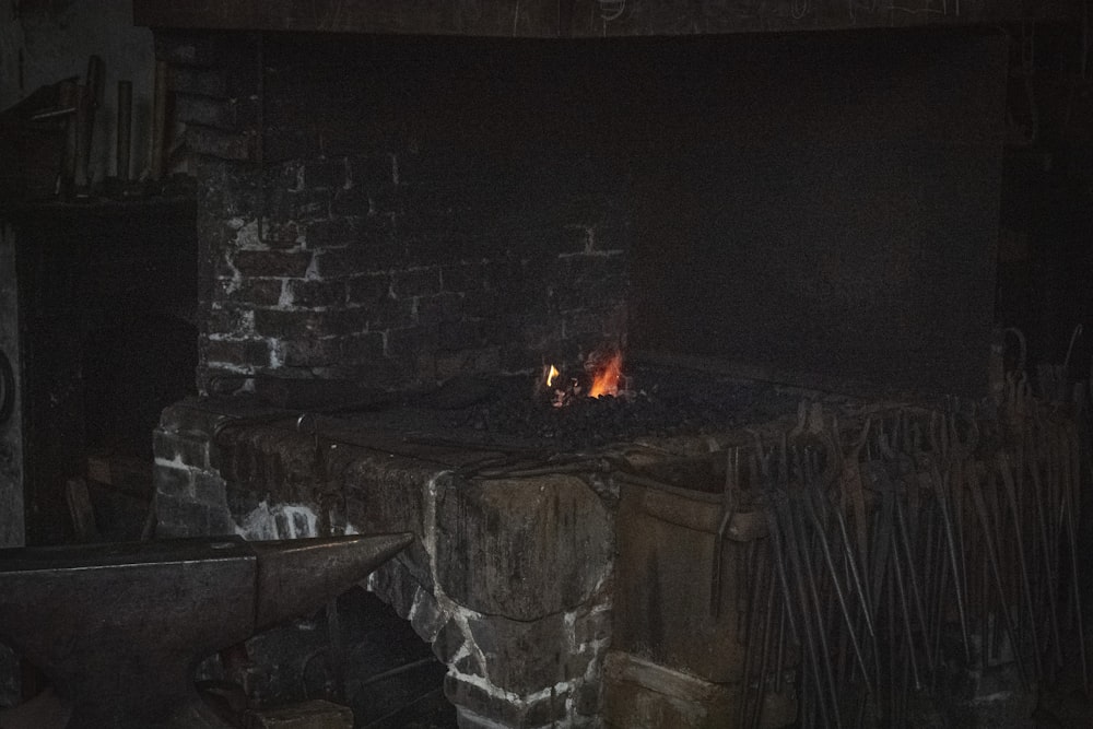 a fire burning in a brick oven in a dark room