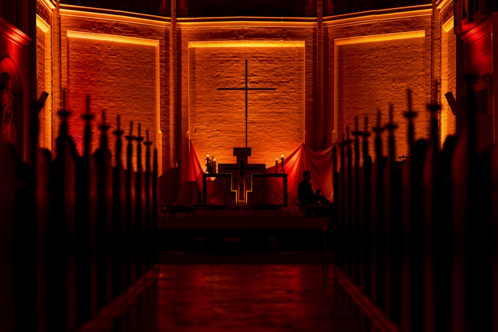 a dimly lit church with a cross on the alter