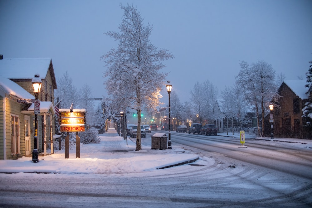 a snowy street with a street light and street signs
