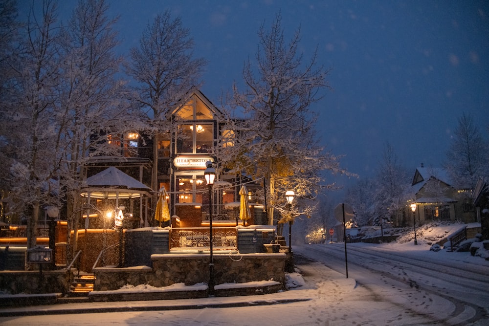 a house is lit up at night in the snow