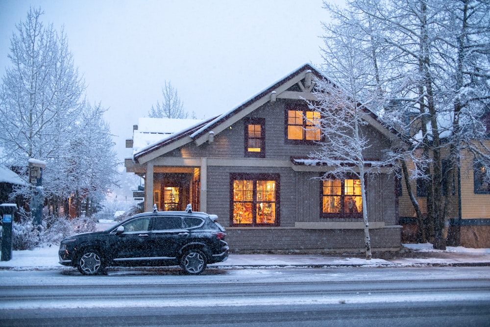 a car parked in front of a house on a snowy day