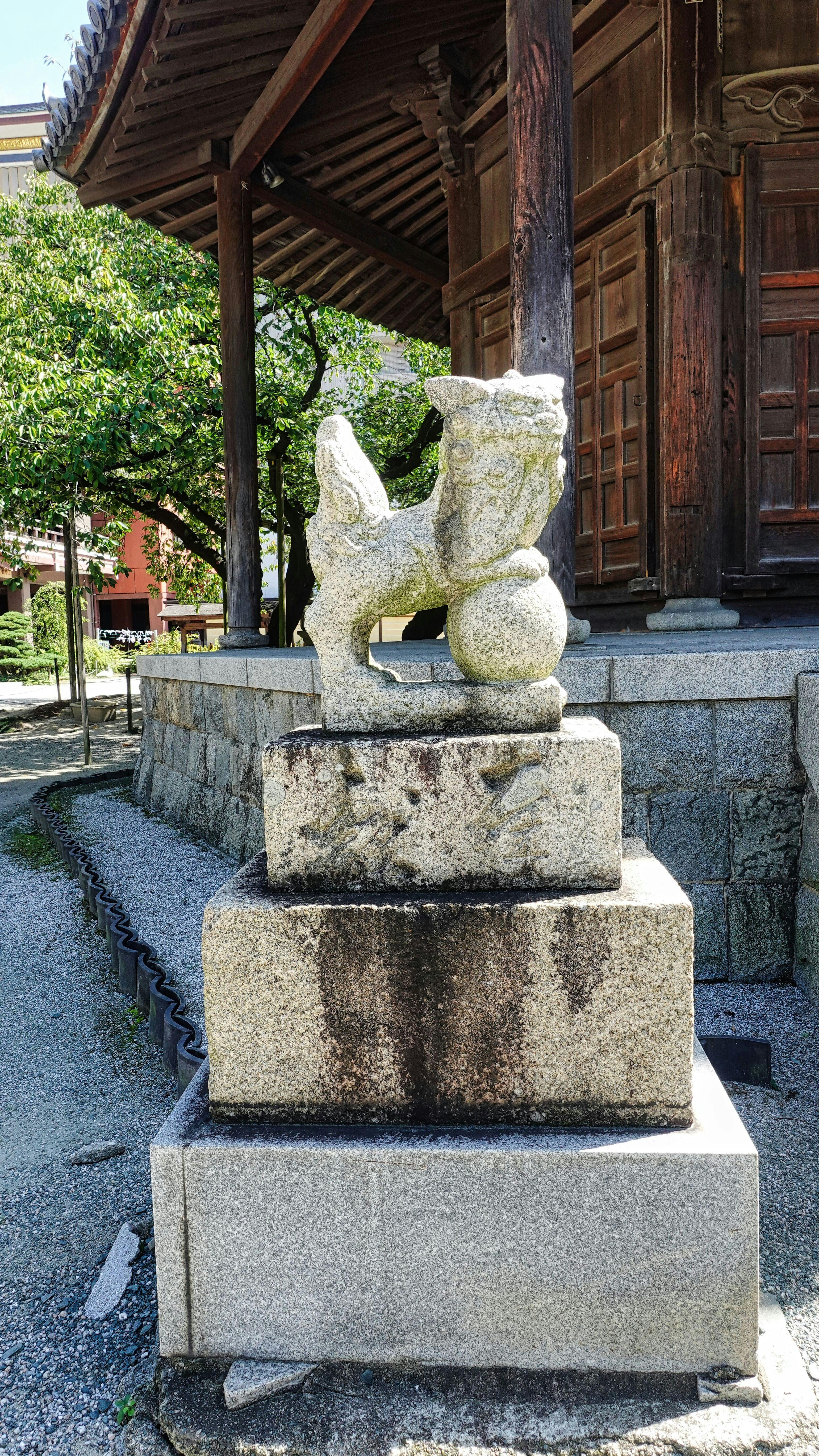 a statue of a bear sitting on top of a stone block