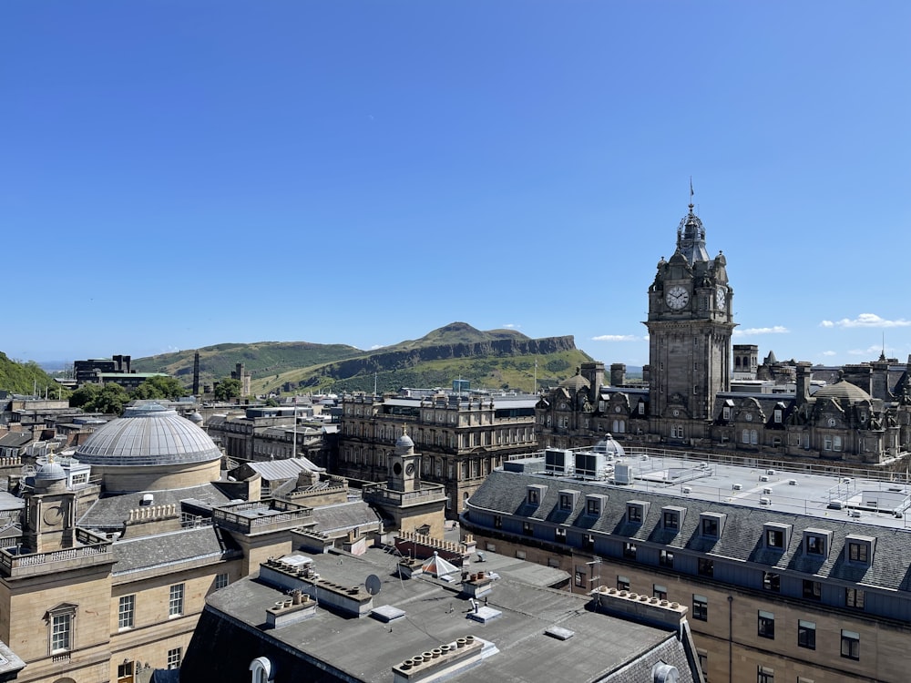 a clock tower towering over a city with mountains in the background