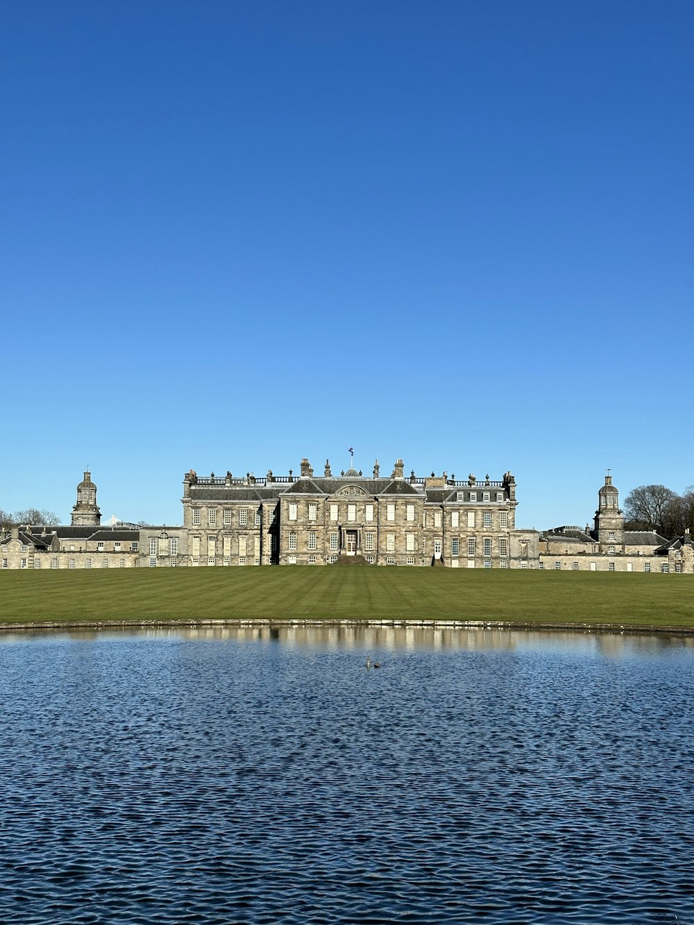 a large building sitting on top of a lush green field