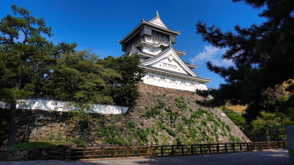 a tall white building sitting on top of a lush green hillside