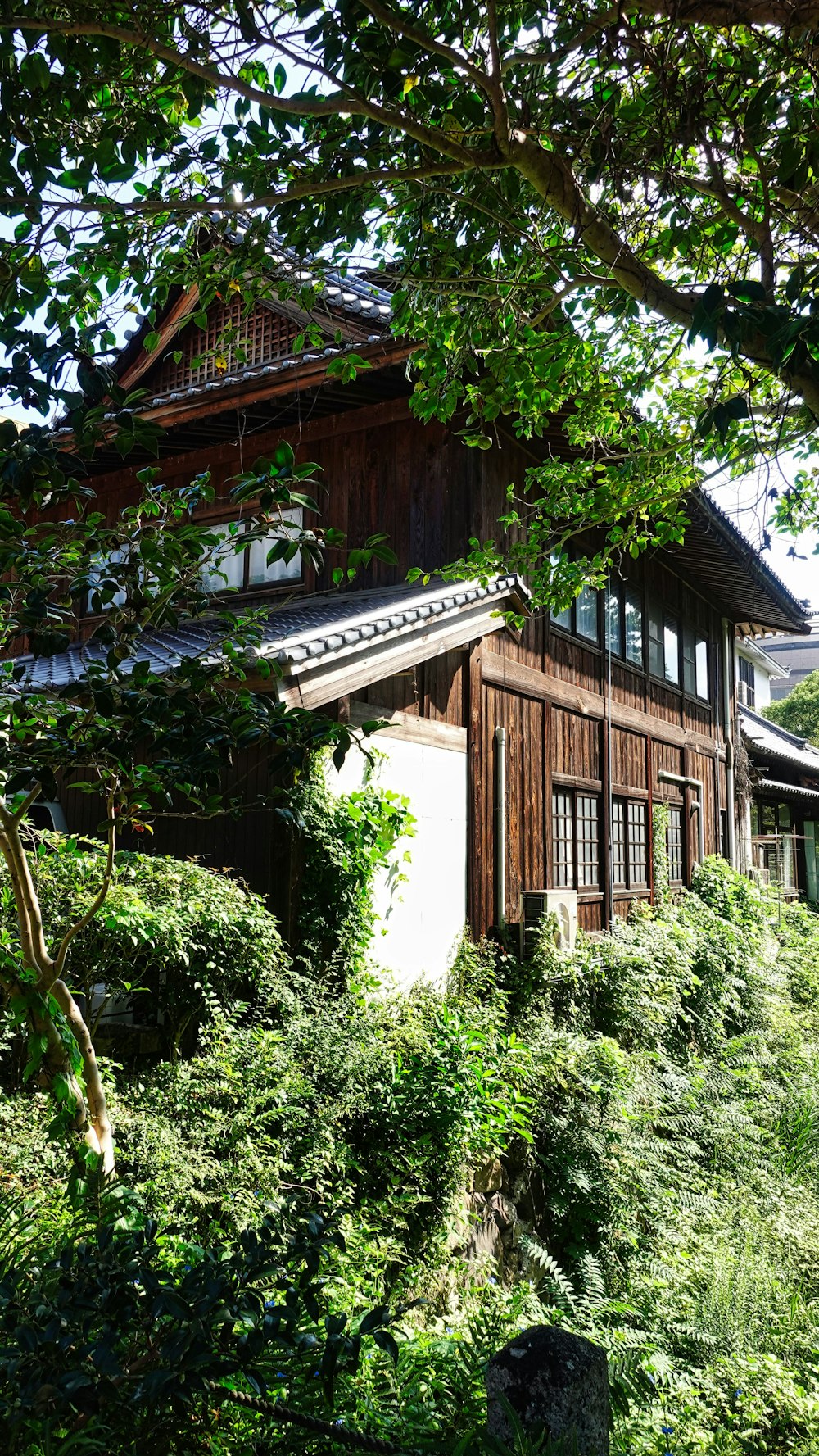 a wooden house sitting on top of a lush green hillside