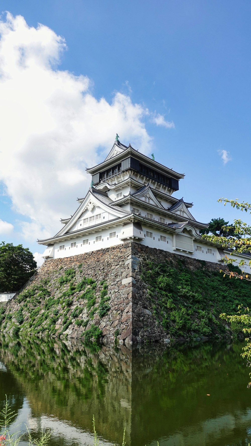 a large building sitting on top of a lush green hillside