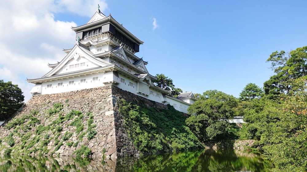 a tall white building sitting on top of a lush green hillside