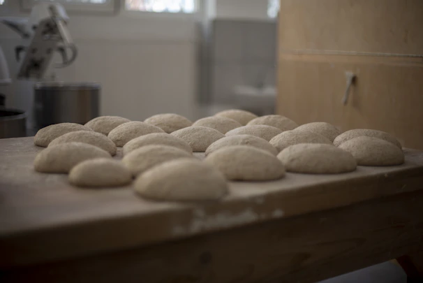 A baker delicately layering dough in a bright, modern bakery setting
