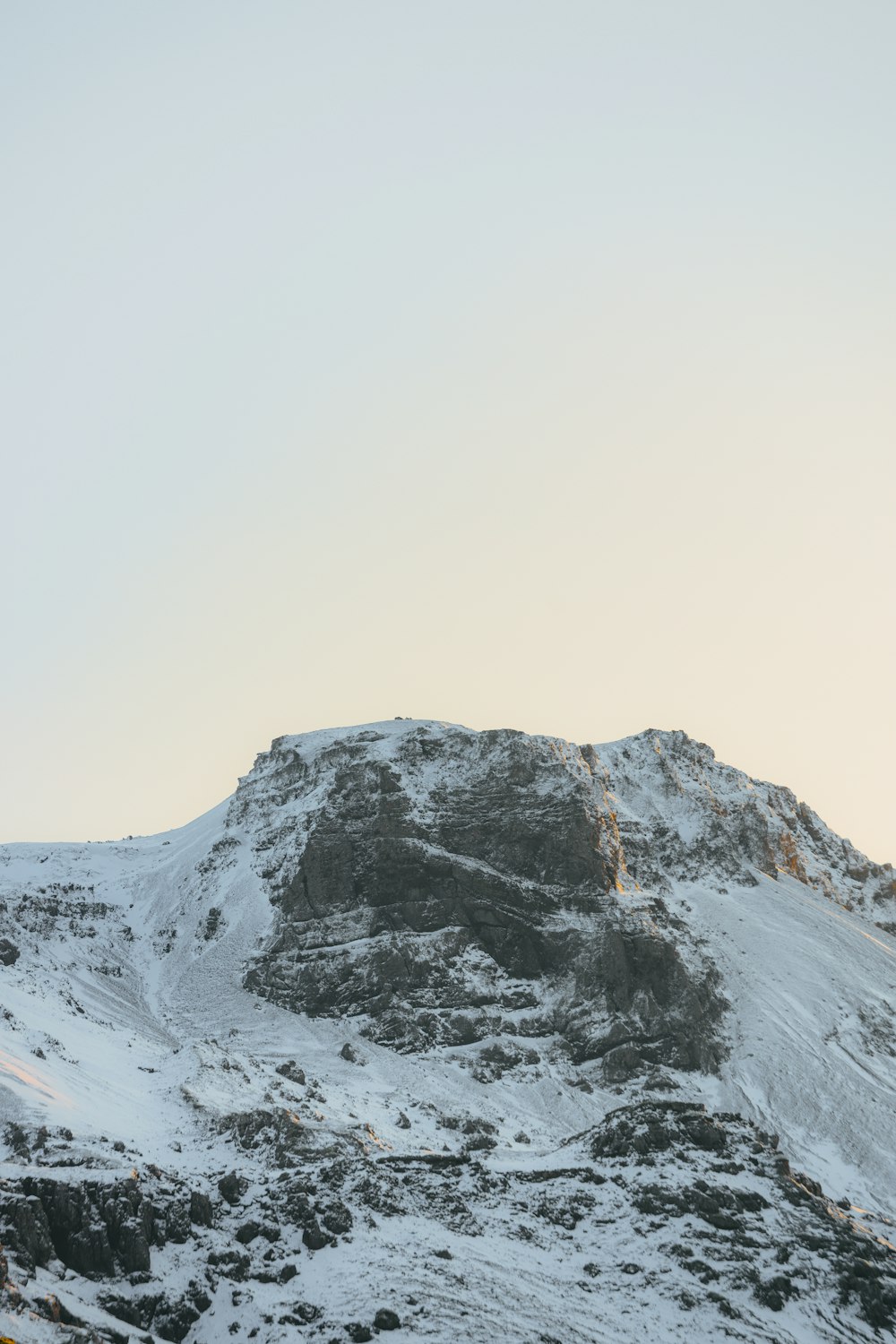 a mountain covered in snow with a sky background