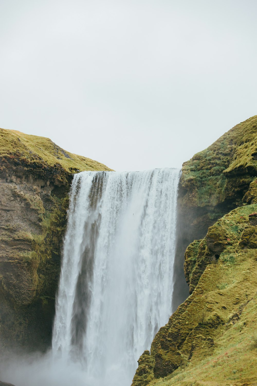 a man standing in front of a waterfall