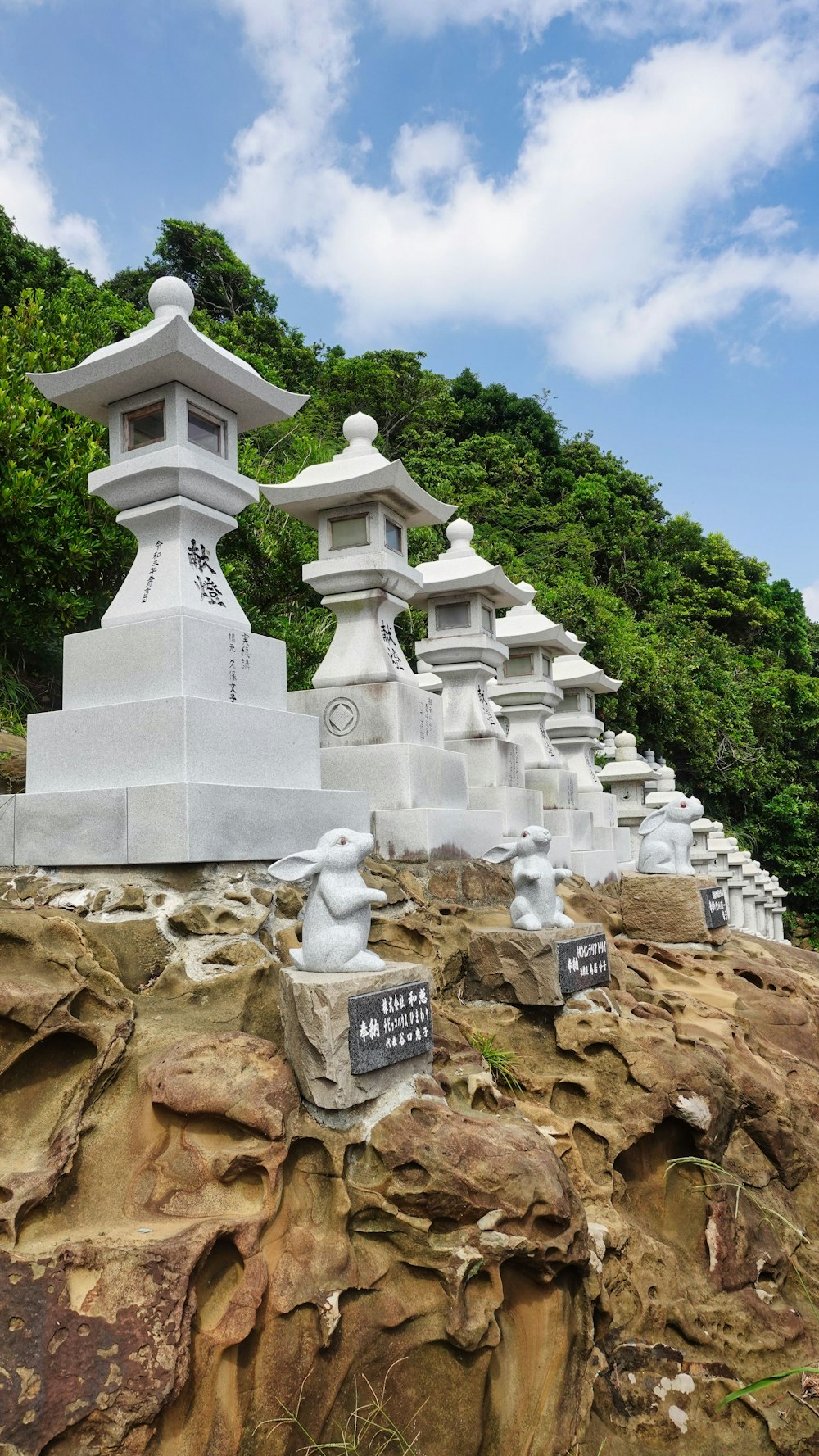 a group of white statues sitting on top of a rocky hillside