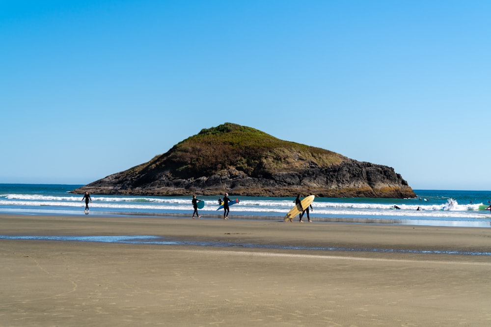 a group of people standing on top of a sandy beach