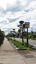 Wide paved road running through a well-planned layout with streetlights and sidewalks