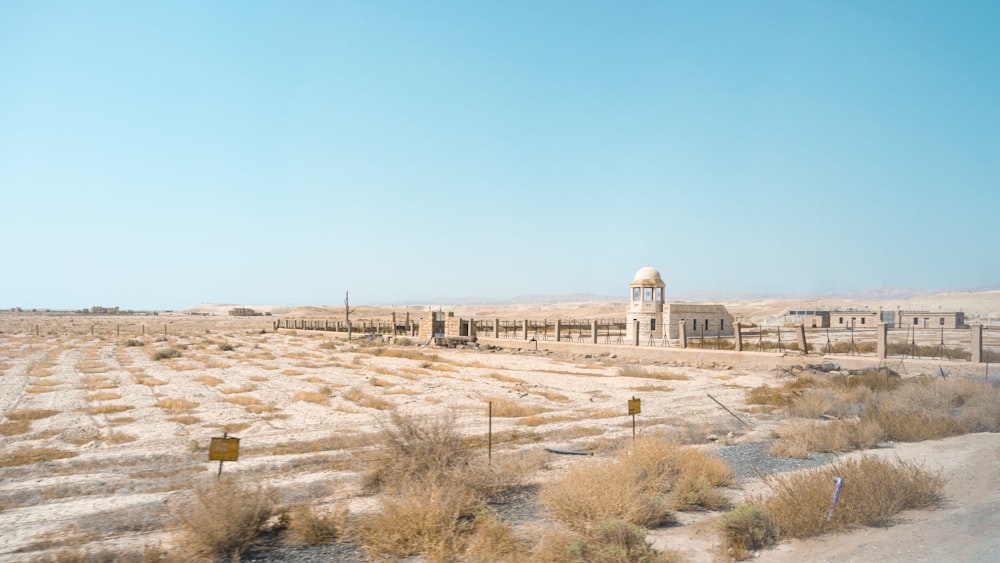 a desert landscape with a large white building in the distance