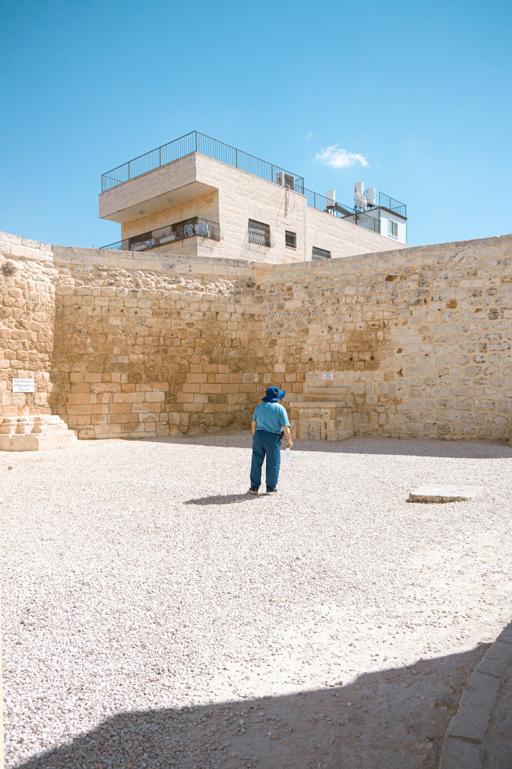 a person standing in a courtyard with a building in the background