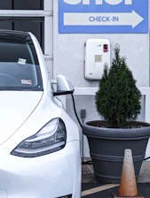 Visual of a marked checklist next to a snowy roadside with a parked electric vehicle.