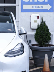 Visual of a marked checklist next to a snowy roadside with a parked electric vehicle.
