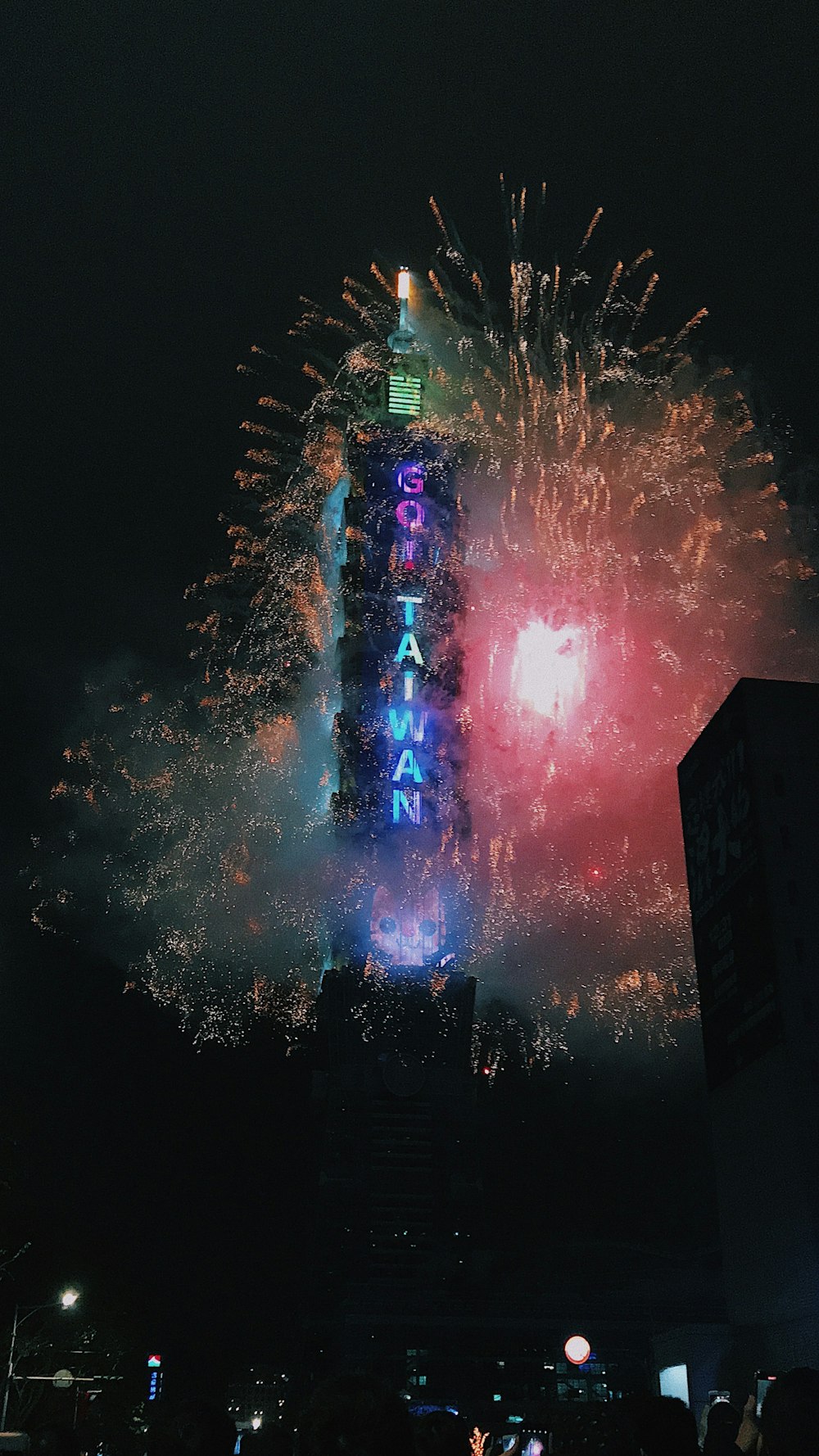 fireworks are lit up in the sky above a building