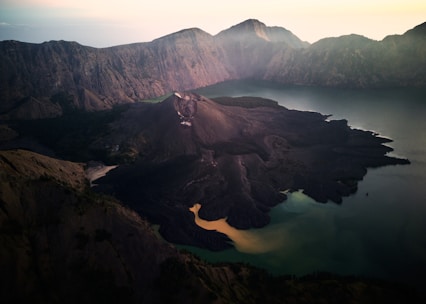an aerial view of a mountain range with a lake in the foreground