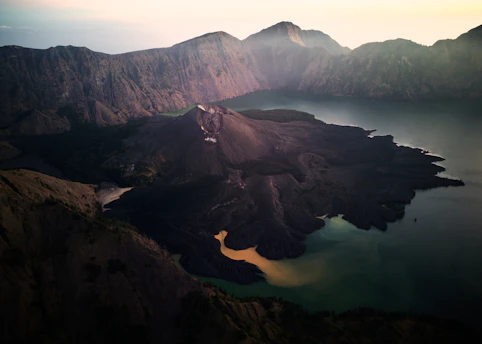 an aerial view of a mountain range with a lake in the foreground