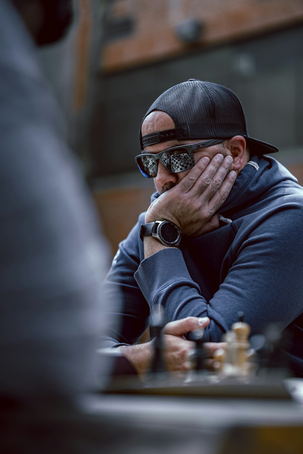 a man sitting at a table with his hands on his face