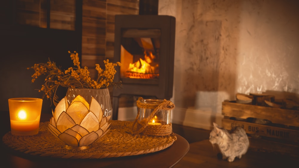 a table with a vase of flowers and a candle on it