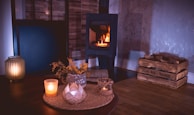 A cozy setting with a gift hamper beside a warm fireplace.