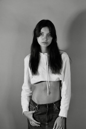 Black and white photo of a model wearing a minimalist Ascension hoodie against a stark urban backdrop.