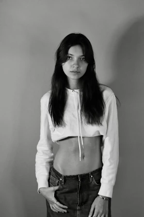 A model wearing a minimalist oversized hoodie in a neutral tone against a white background.