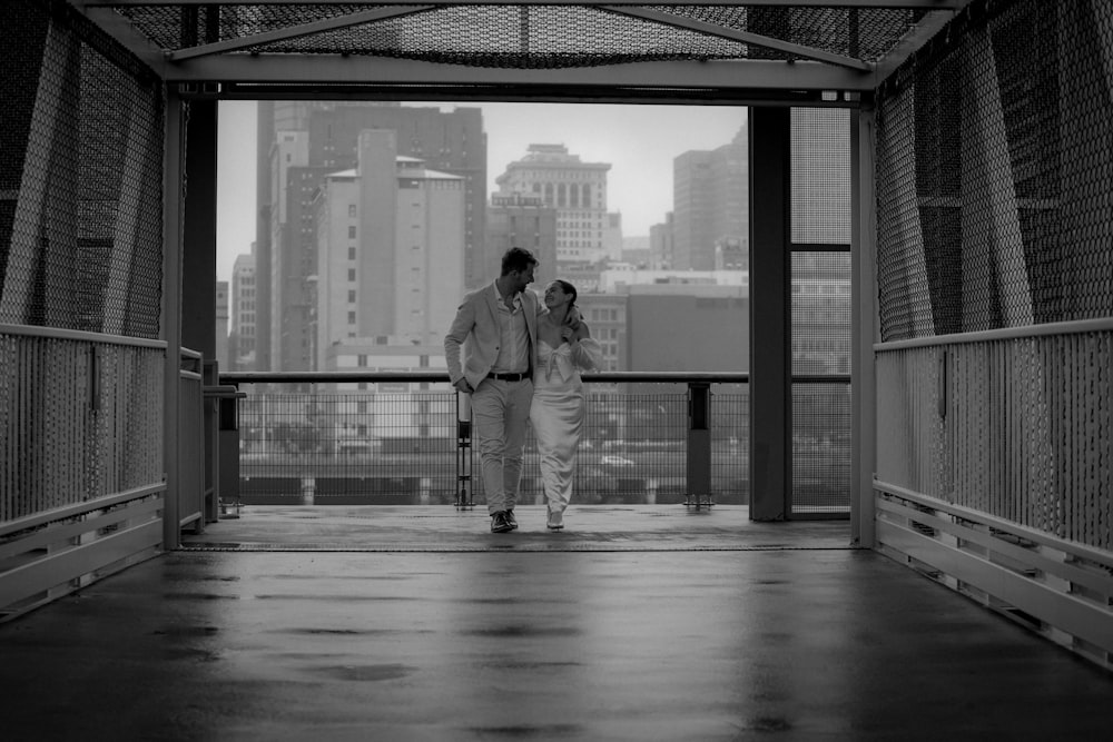 a man and a woman walking across a bridge