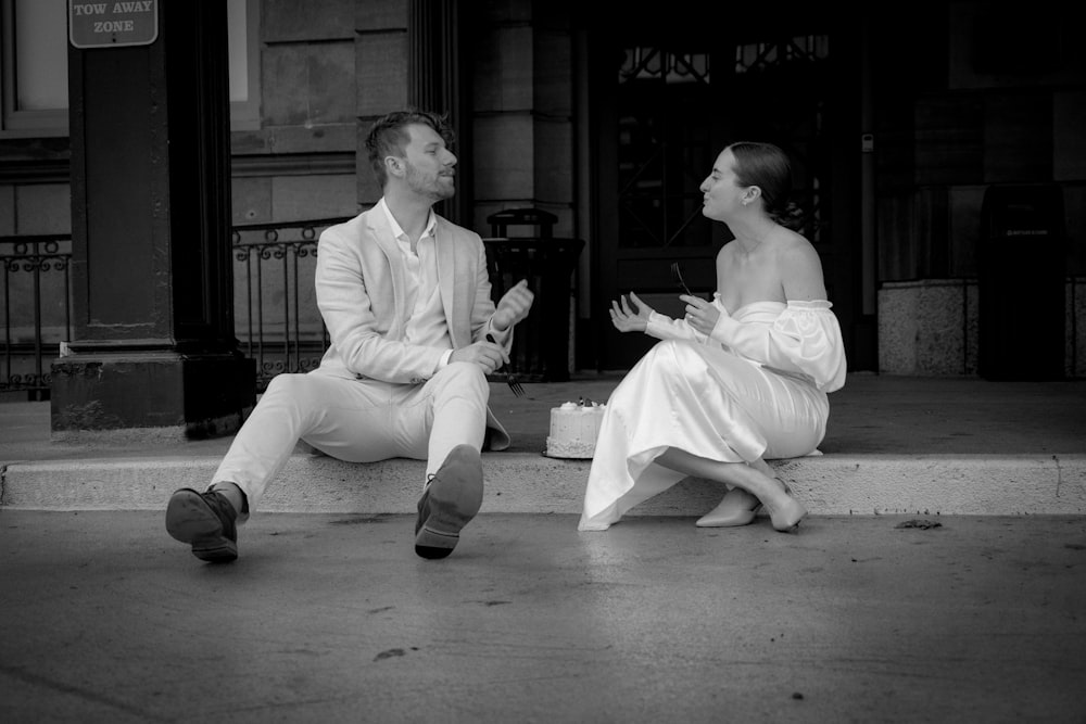 a man and a woman sitting on the steps of a building