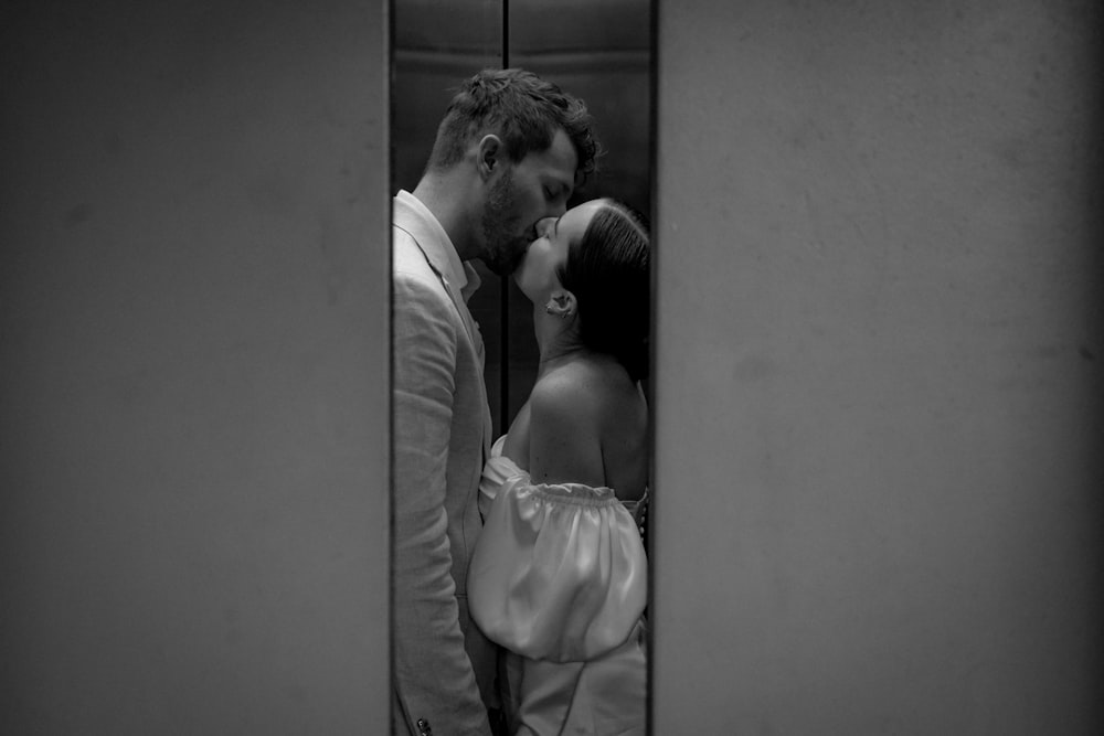 a man and a woman kissing in a mirror