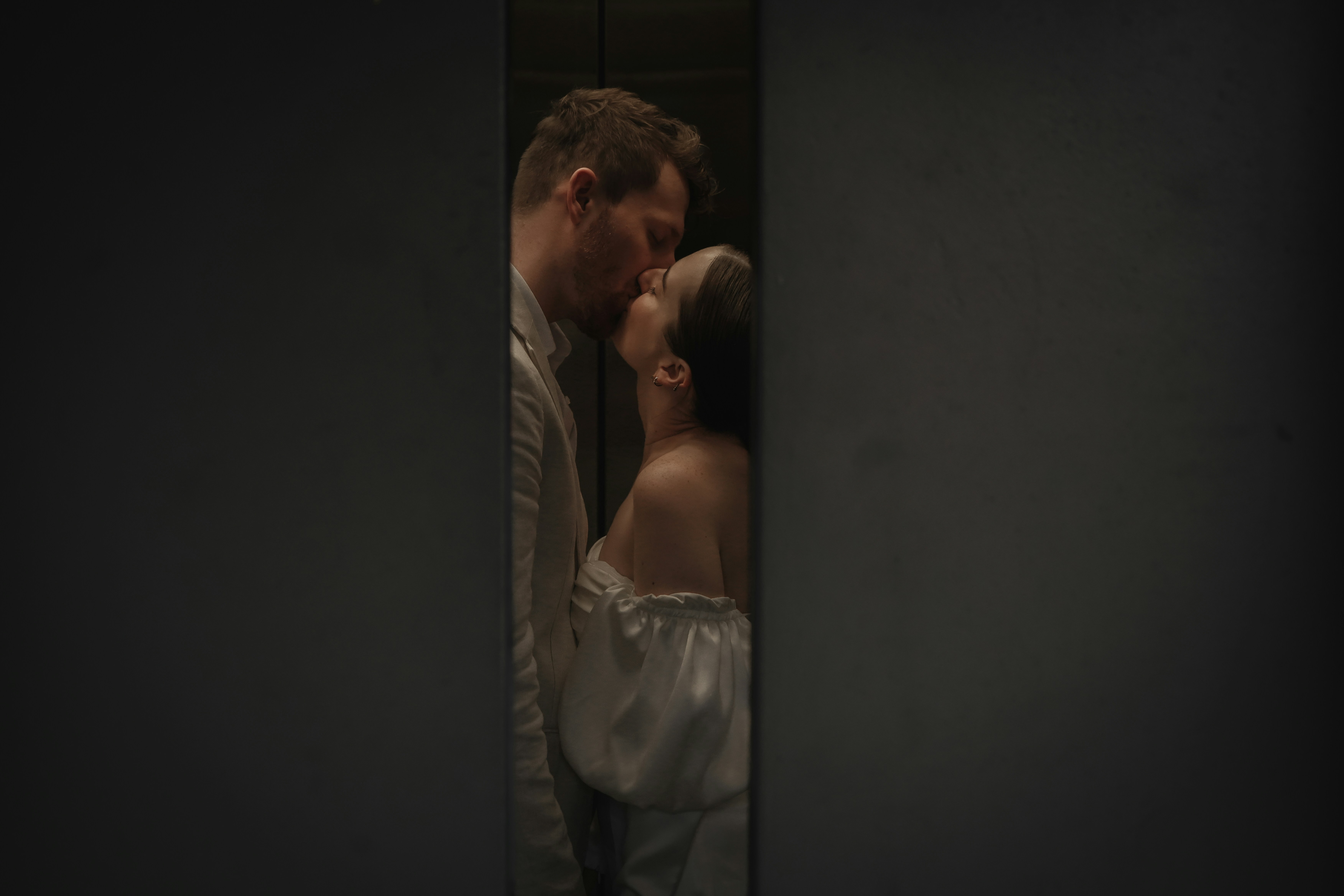 a man and a woman kissing in a dark room