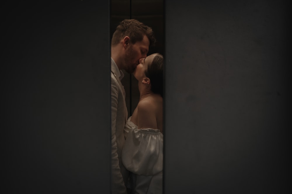 a man and a woman kissing in a dark room