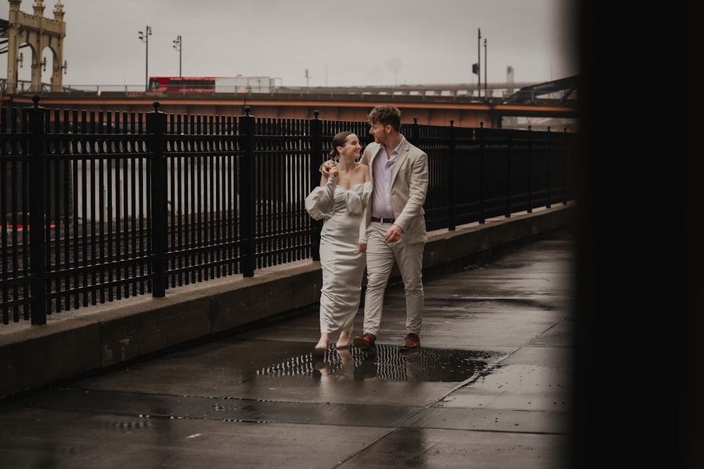 a man and a woman standing on a bridge in the rain