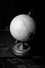 a black and white photo of a globe on a stand