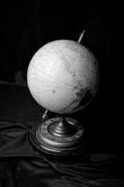 a black and white photo of a globe on a stand