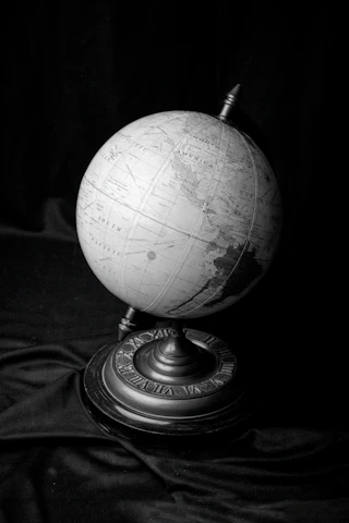 a black and white photo of a globe on a stand
