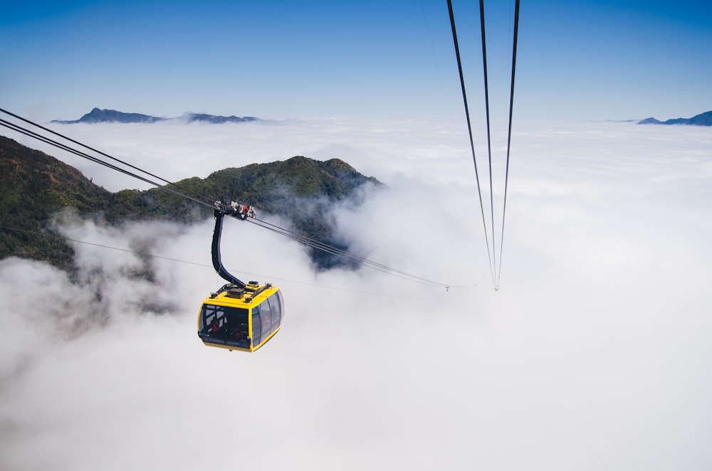 a cable car is above the clouds in the sky