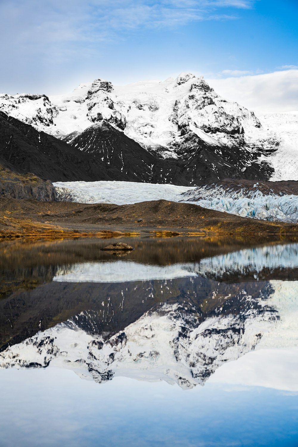 a mountain range with a lake in the foreground