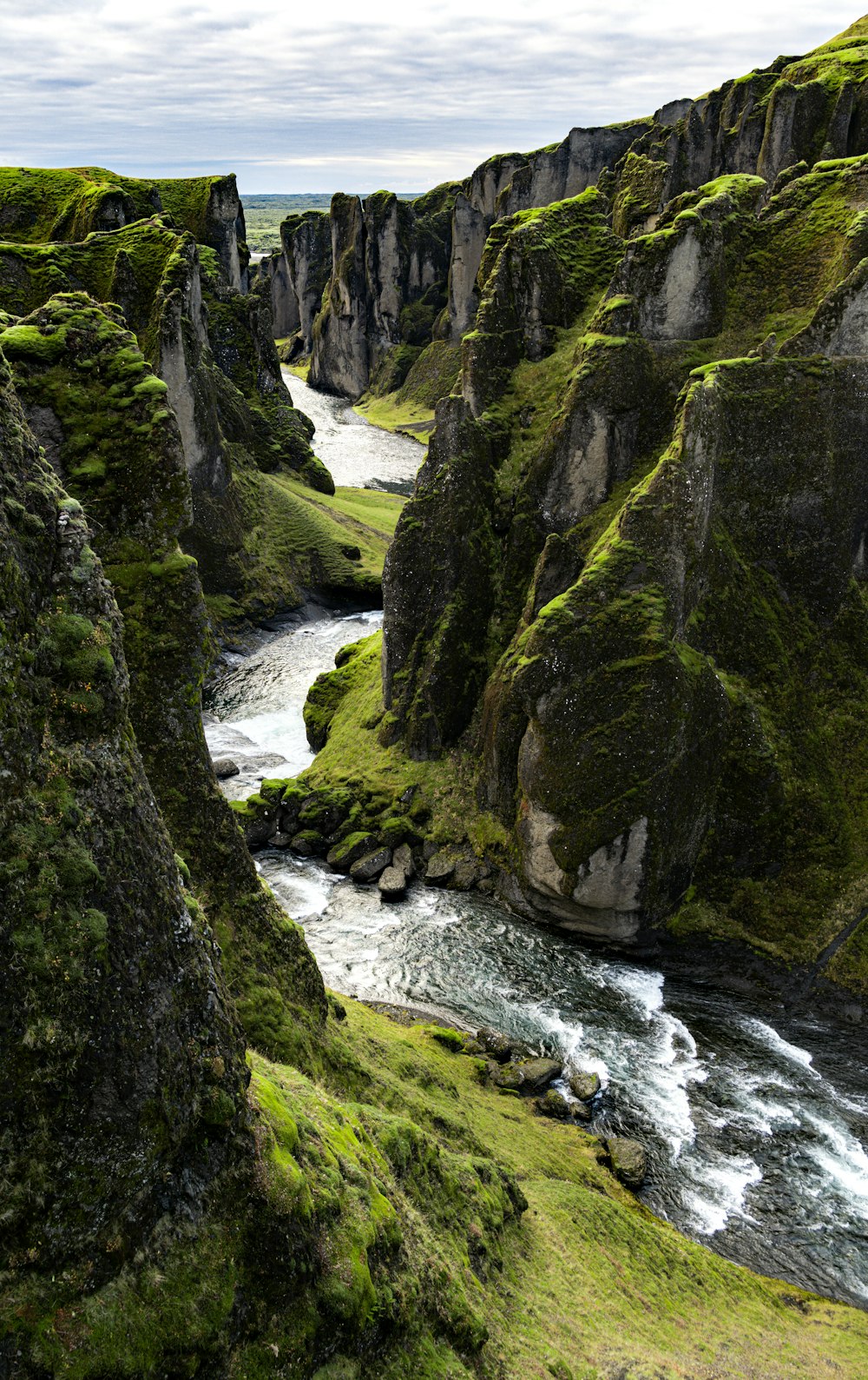 a river flowing through a lush green valley