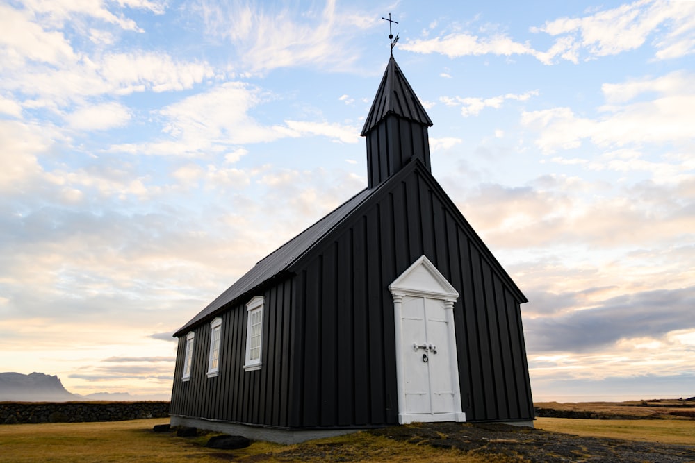 a black church with a white door and a steeple