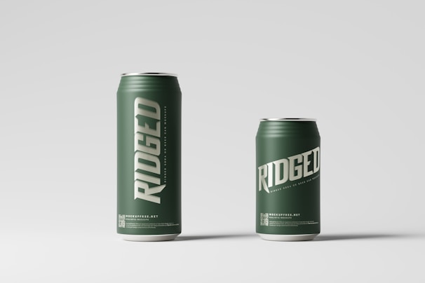 Two green beverage cans labeled 'RIDGED' are displayed against a light gray background. The can on the left is taller than the one on the right, and both have a clean, minimalist design with bold white text.