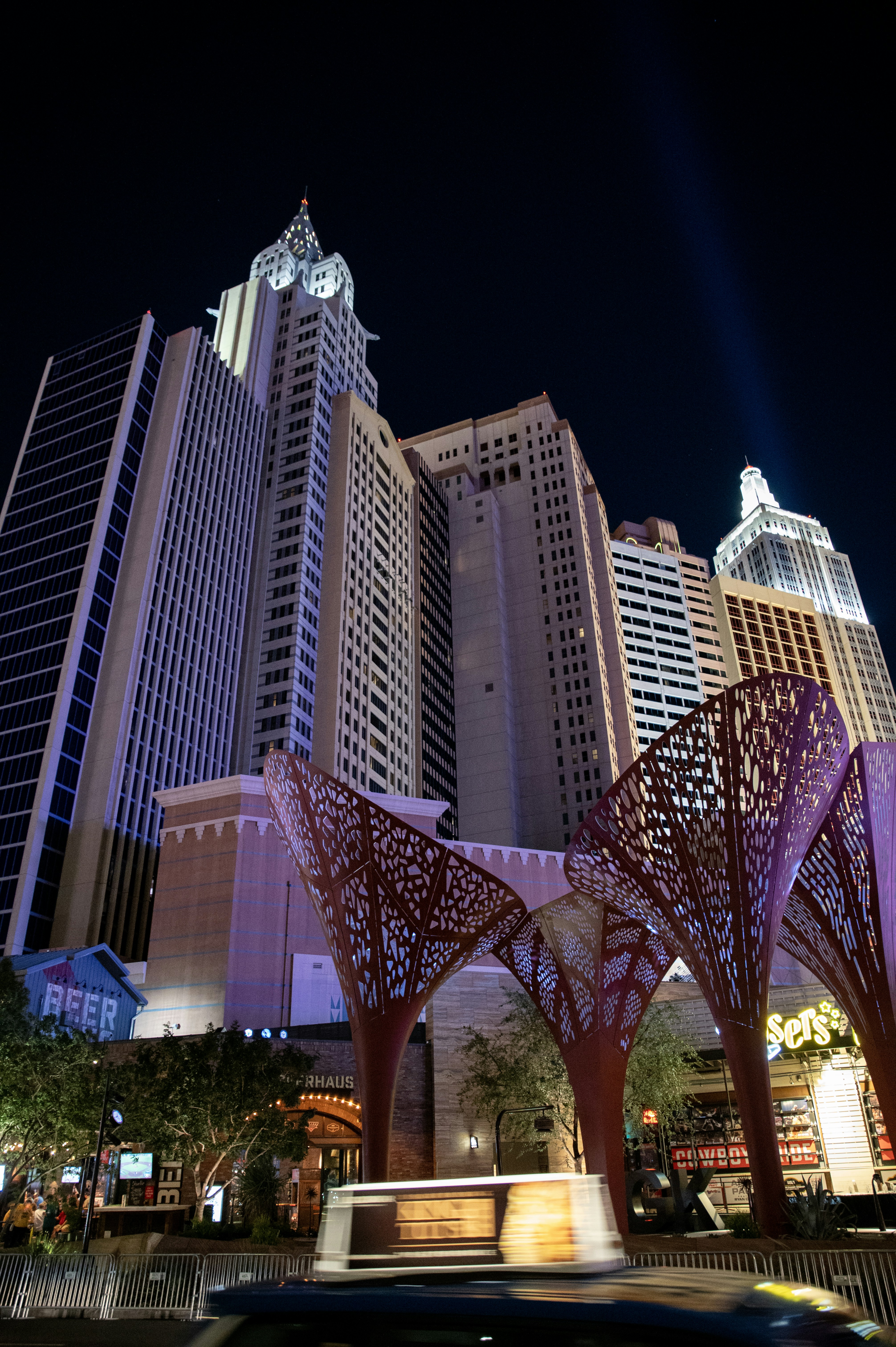 um carro passando por um prédio alto à noite