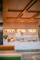 Cozy modern store counter with warm lighting and fresh flowers.