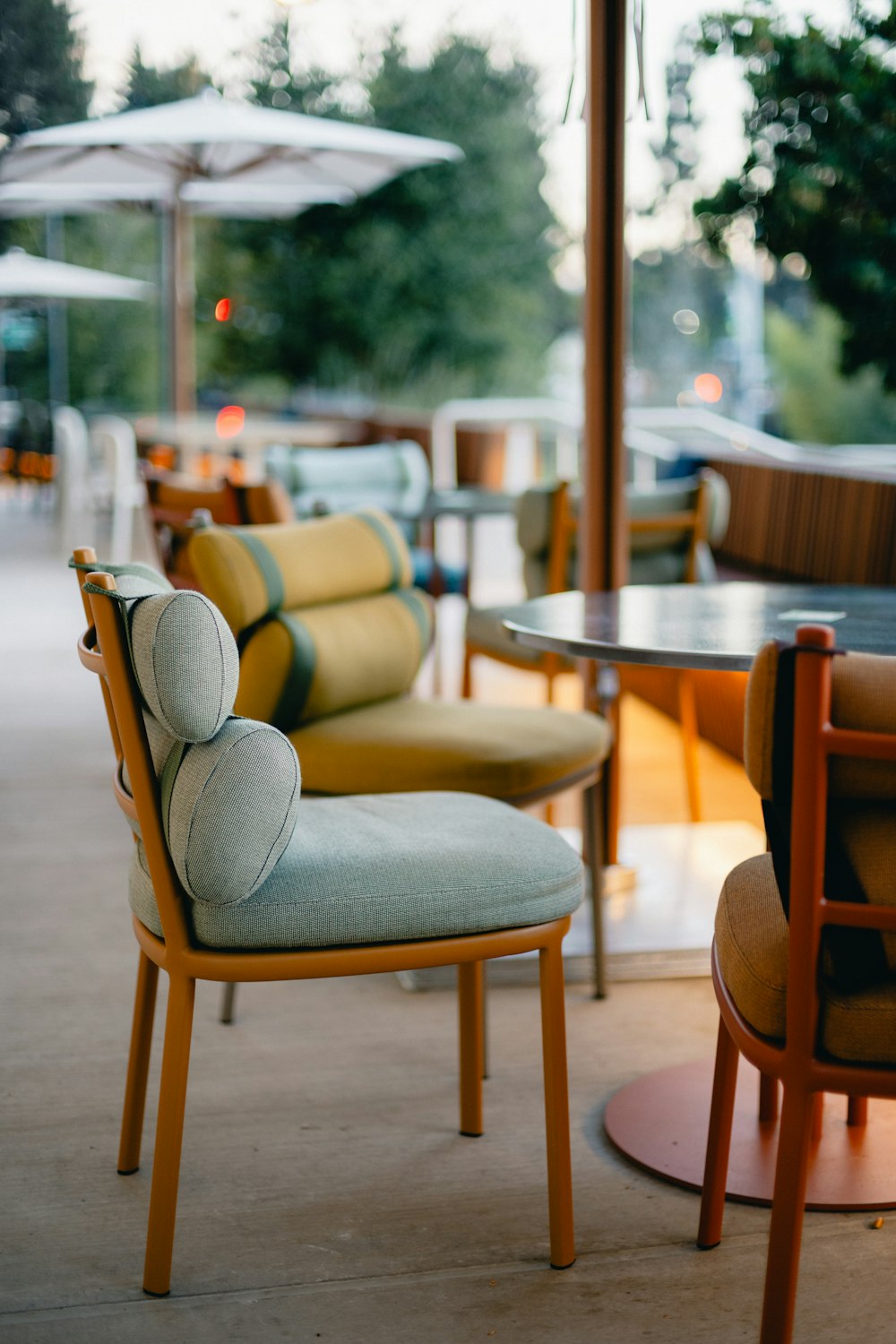 a row of chairs sitting next to each other under an umbrella