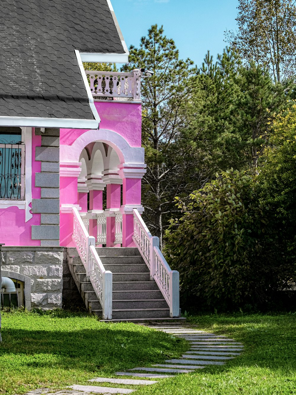 a pink and grey house with steps leading up to it